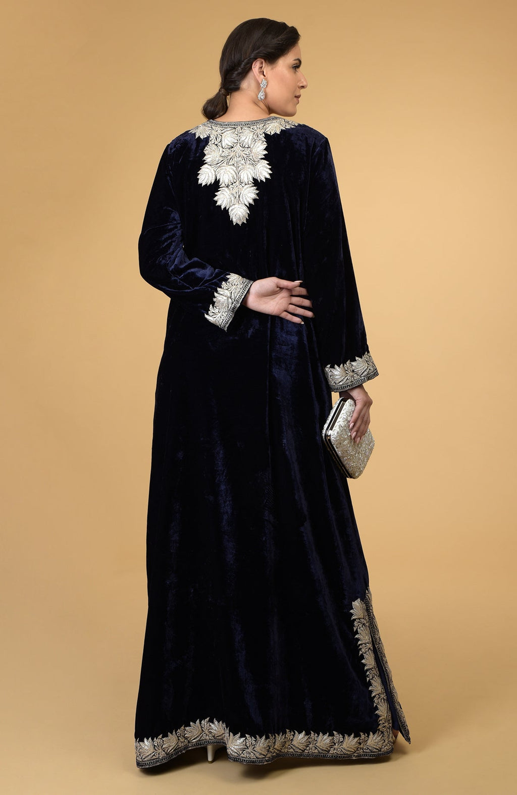 A woman models a midnight blue velvet kaftan with silver Kashmir embroidery.