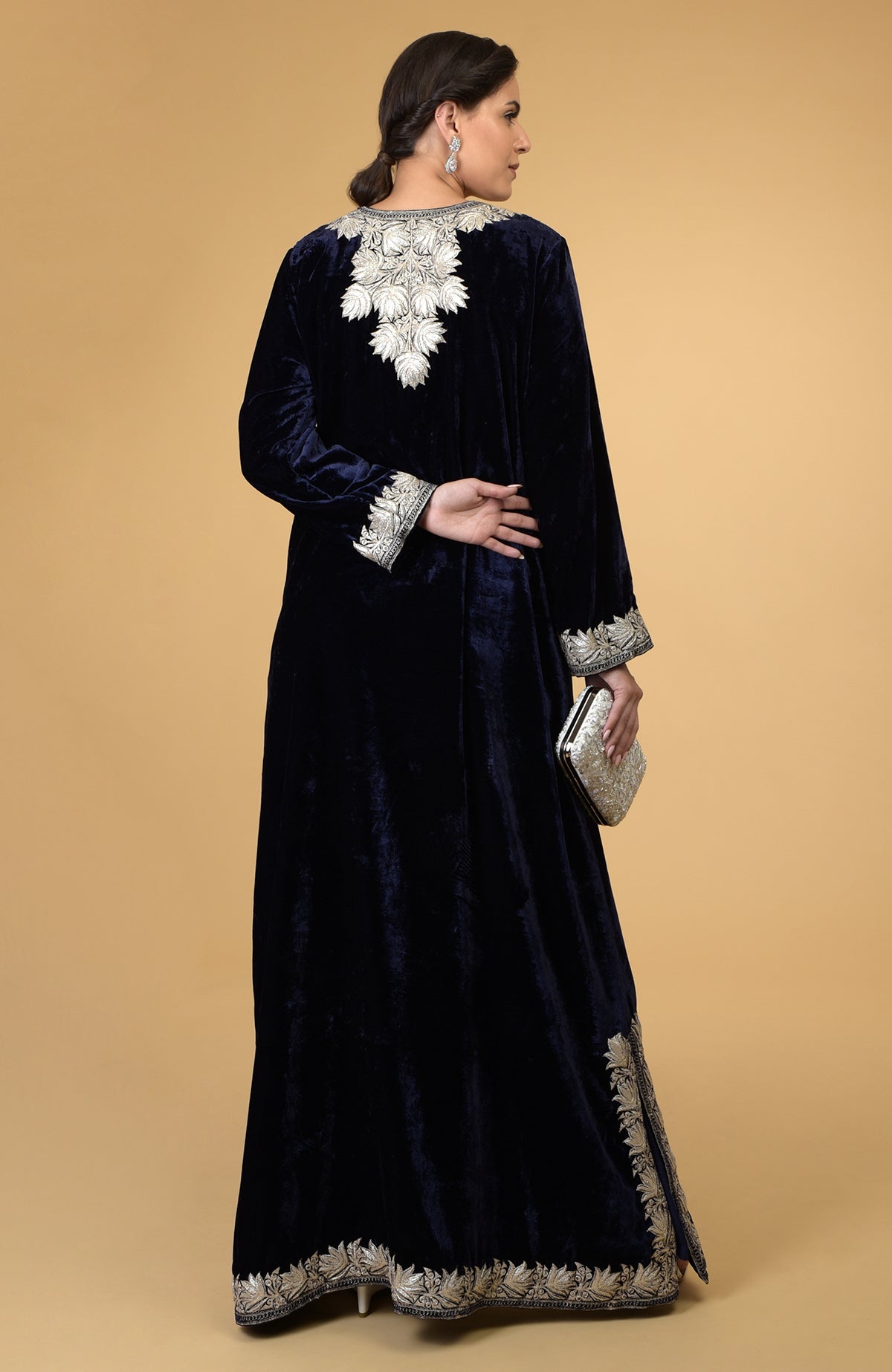 A woman models a midnight blue velvet kaftan with silver Kashmir embroidery.