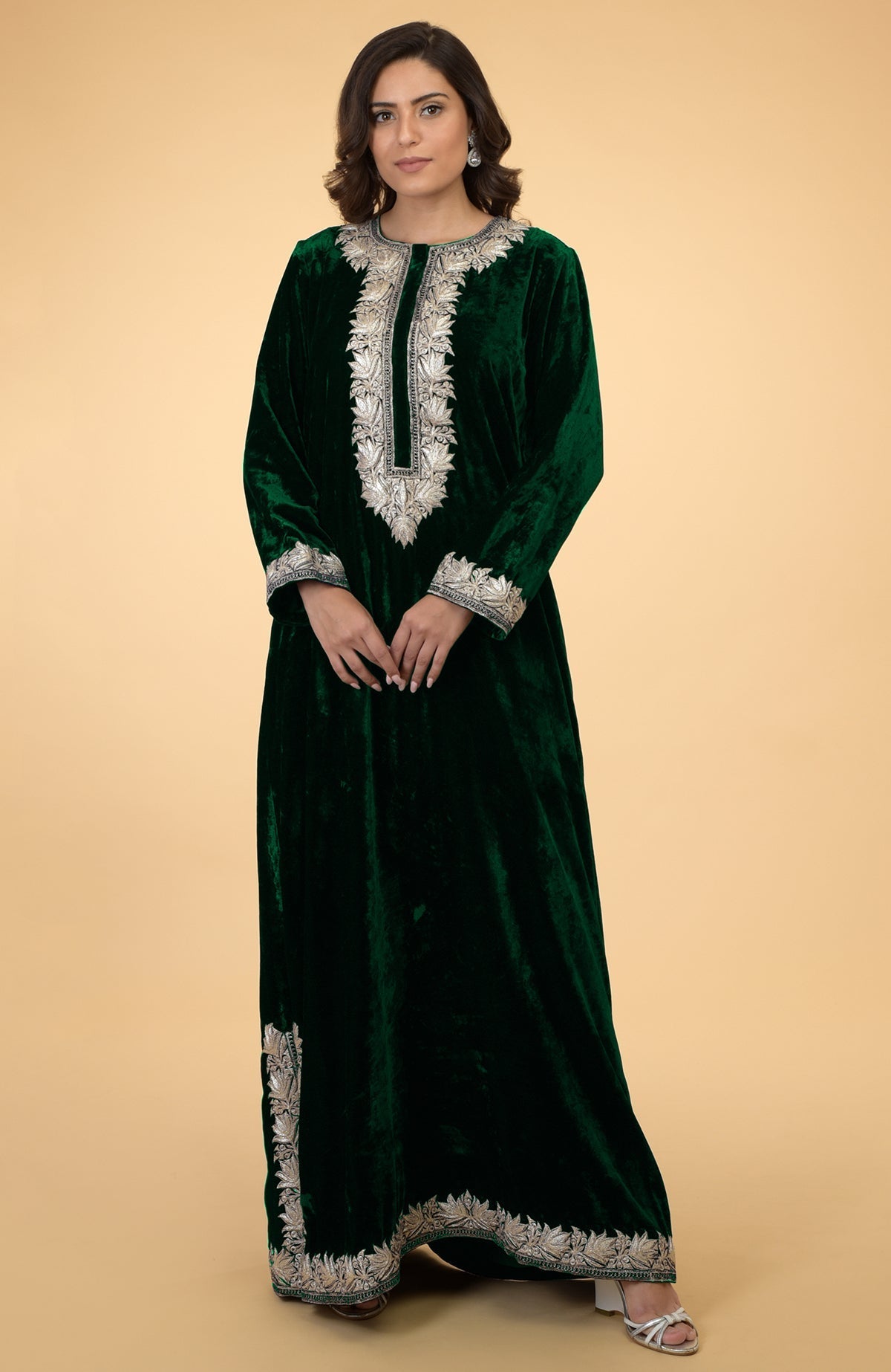 Emerald green velvet kaftan with silver Kashmir embroidery, worn by a woman.