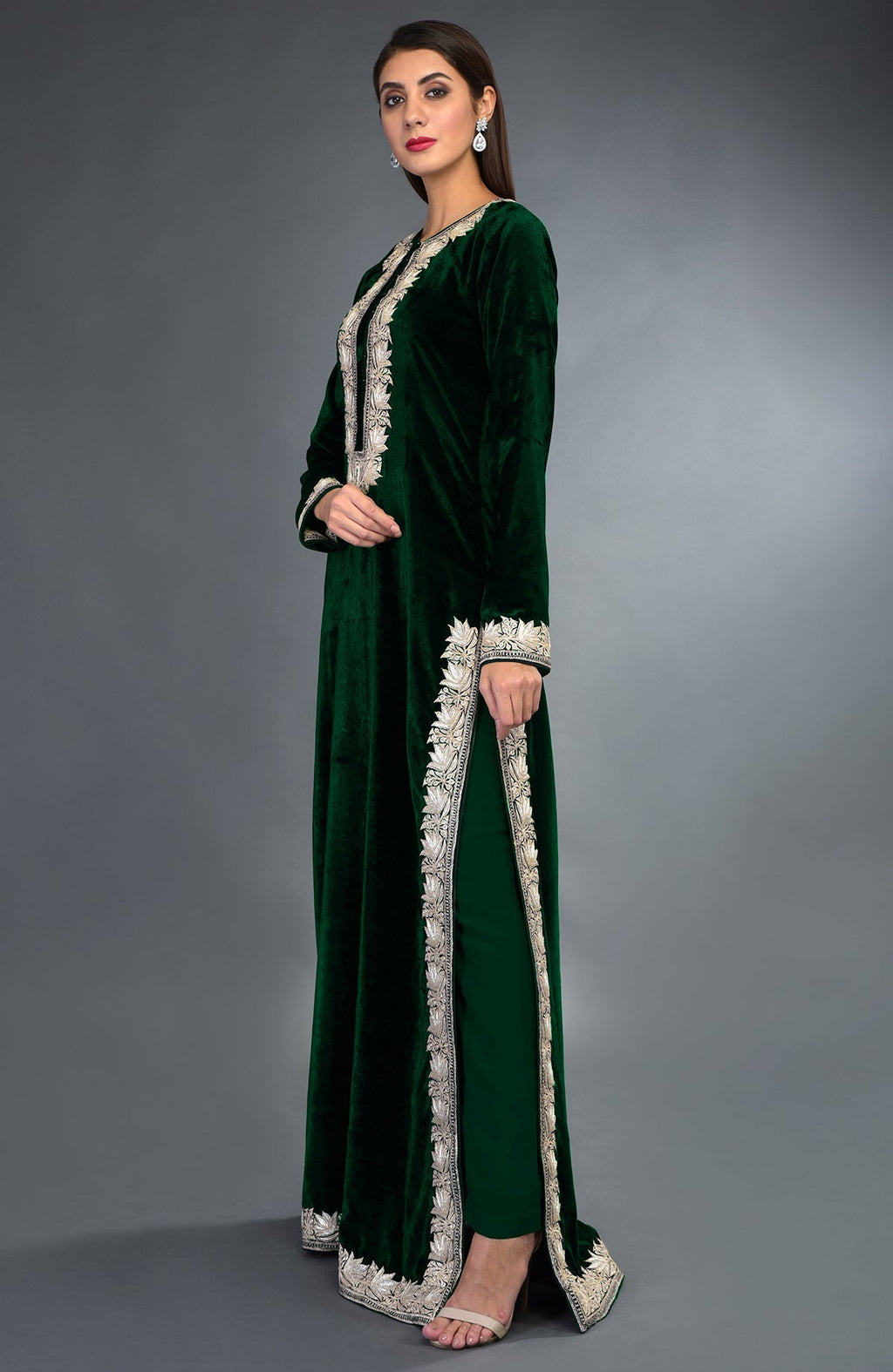 A woman models an emerald green velvet suit with silver tilla embroidery.