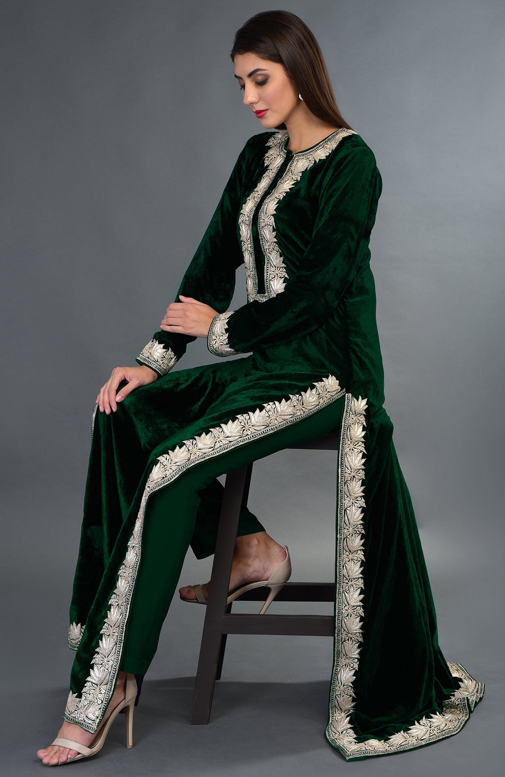 A woman models an emerald green velvet suit with silver tilla embroidery.