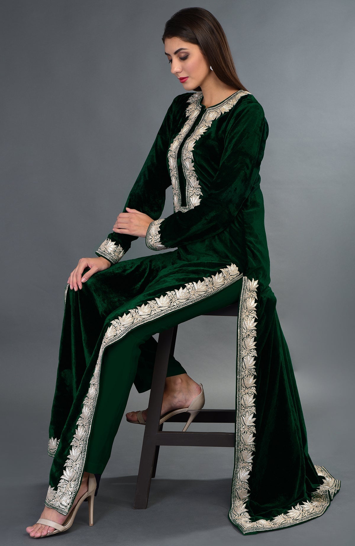 A woman models an emerald green velvet suit with silver tilla embroidery.