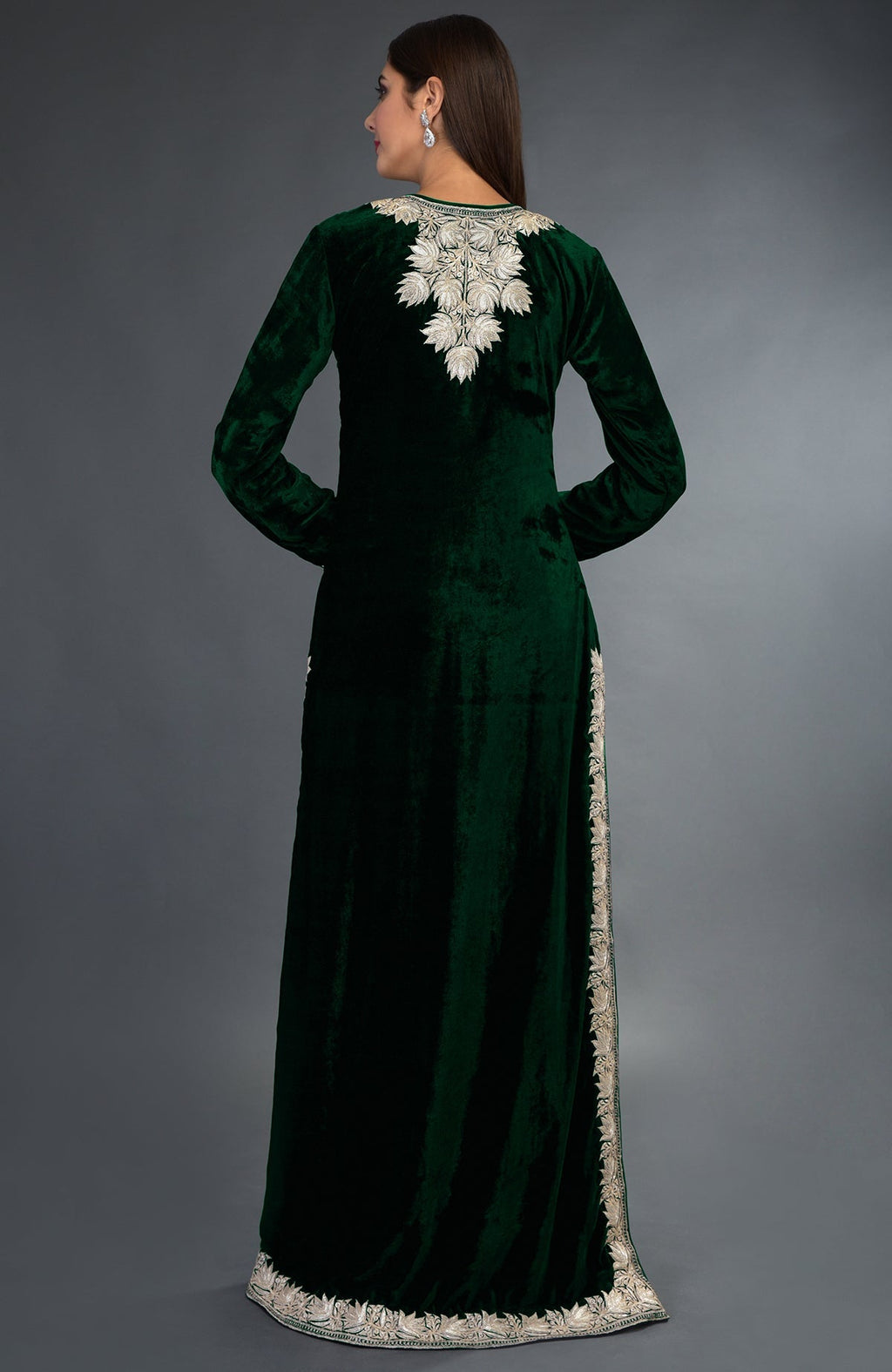 A woman models an emerald green velvet suit with silver tilla embroidery.