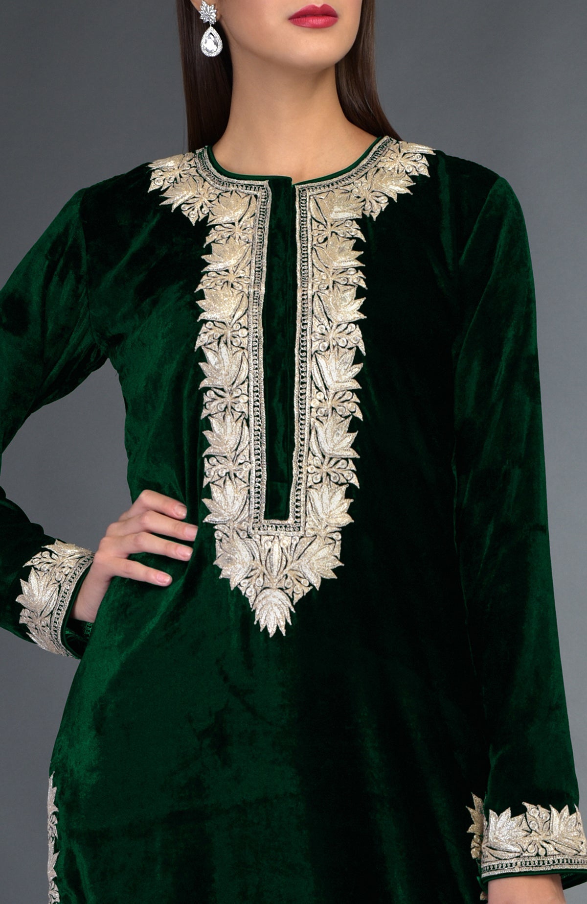 An emerald green velvet suit with silver tilla embroidery on the neckline and sleeves.