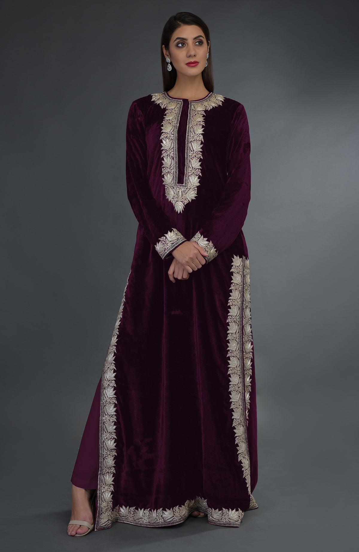 A woman models a plum velvet suit with silver tilla embroidery.