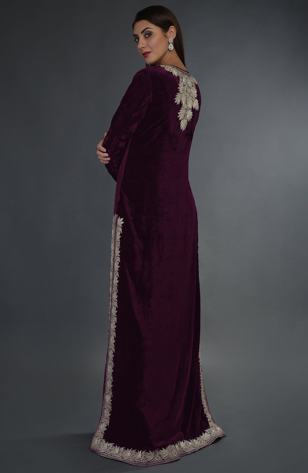 A woman models a plum velvet suit with silver tilla embroidery.