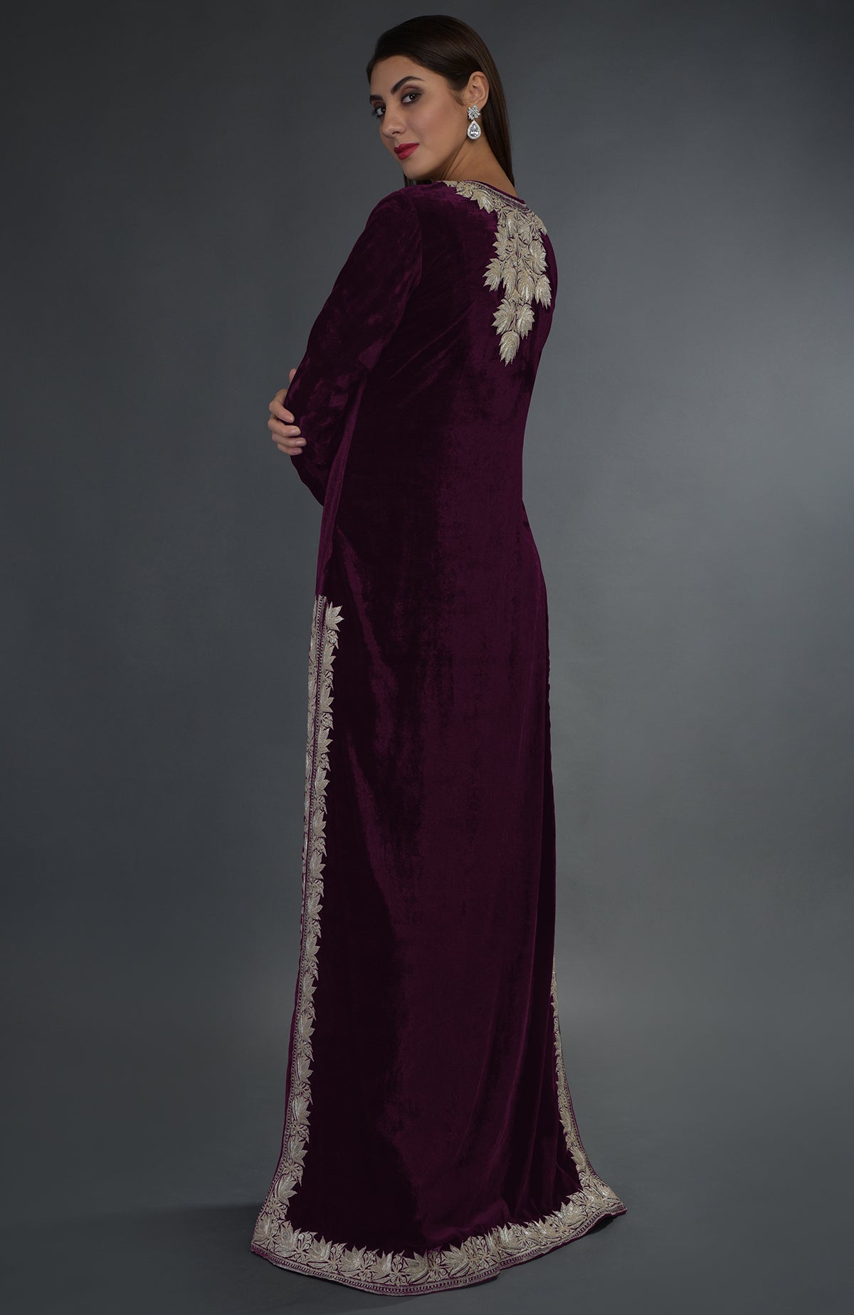 A woman models a plum velvet suit with silver tilla embroidery.