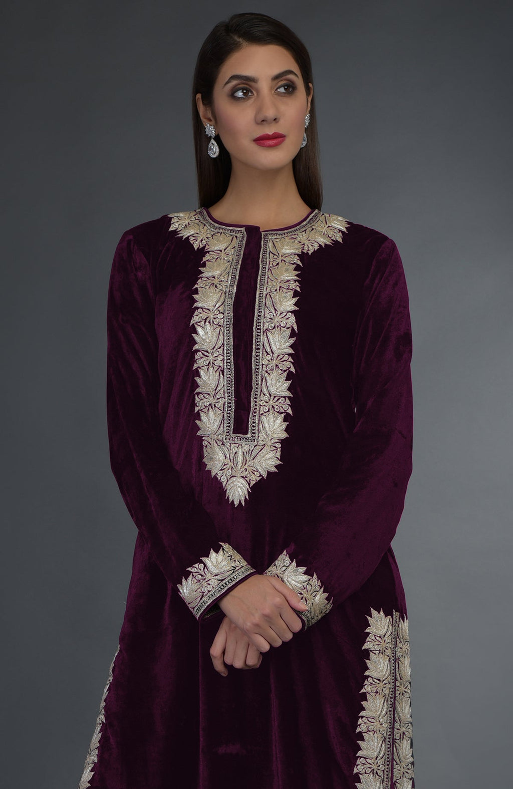 A woman models a plum velvet suit with silver tilla embroidery.