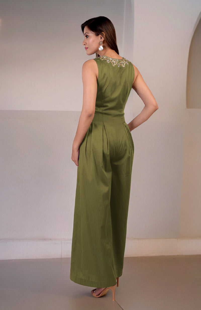 A woman models a green moss jumpsuit with gold tilla hand embroidery.