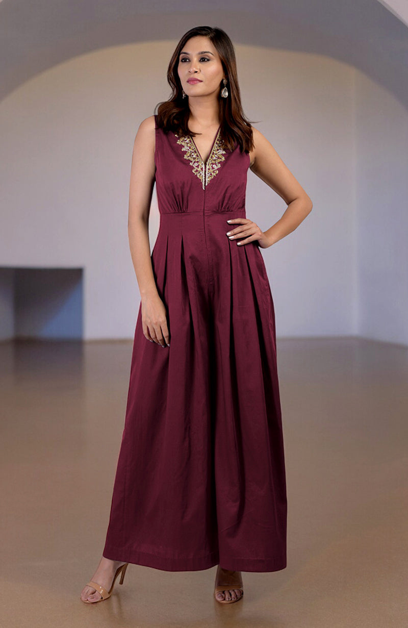 Red plum jumpsuit with gold tilla hand embroidery and a V-neckline.