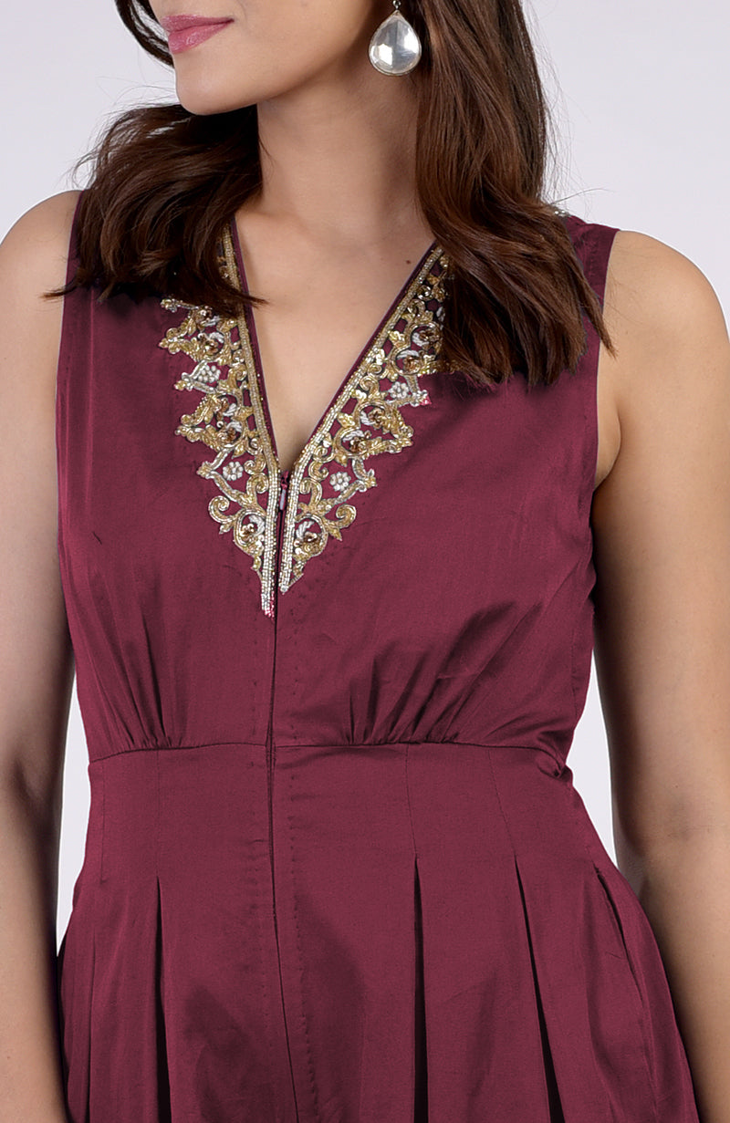 Red plum jumpsuit with gold tilla and bead embroidery on the V-neckline.