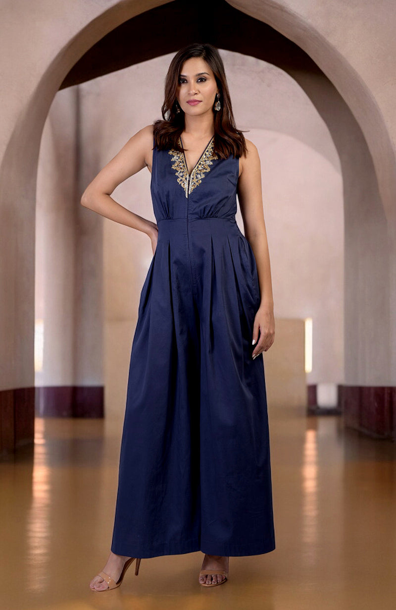 Blue jumpsuit with gold tilla hand embroidery, V-neck, and front pleats.