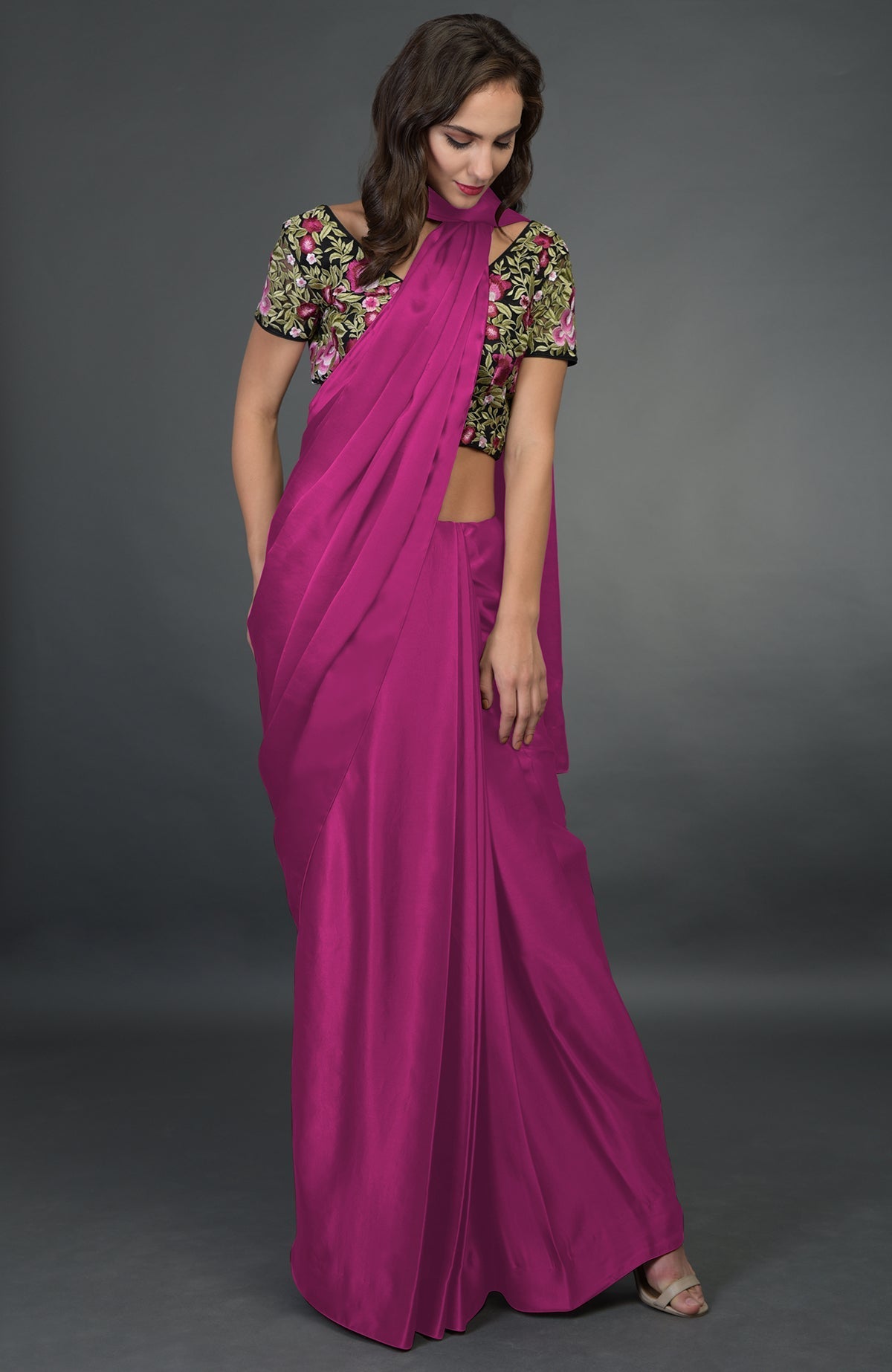 A woman models a raspberry saree with a floral embroidered blouse.