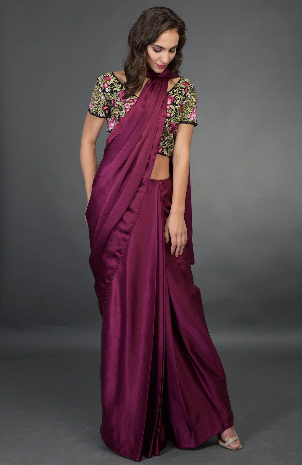 A woman models a plum satin silk saree with a floral embroidered blouse.
