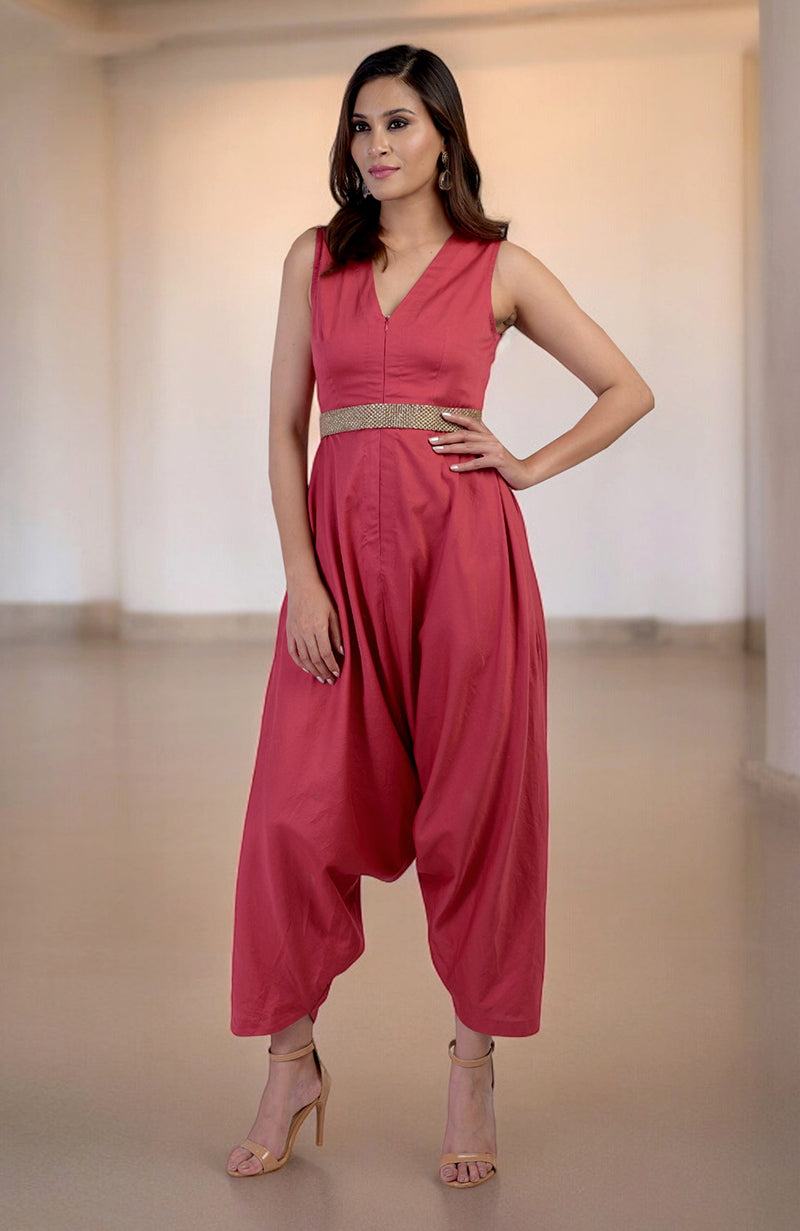 Red jumpsuit with a V-neckline, a gold embroidered belt, and afgani-style pants.