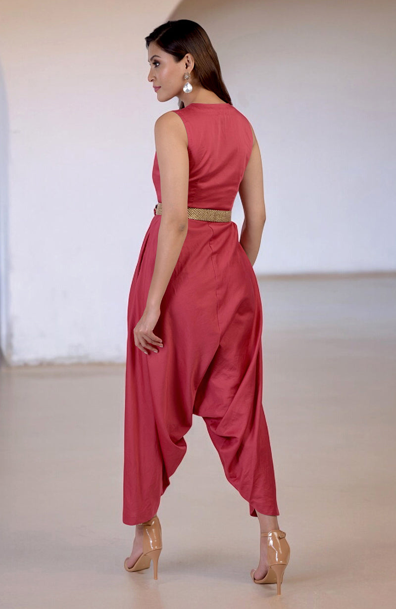 Red V-neck jumpsuit with a gold embroidered belt and afgani-style pants.