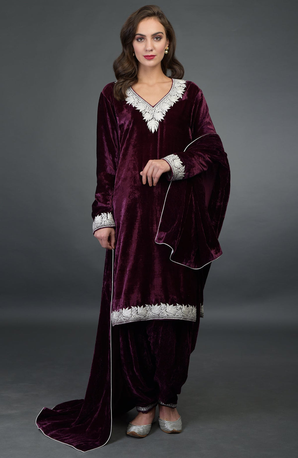 A woman models a dark plum silk-velvet Patiala salwar suit with silver Tilla embroidery.