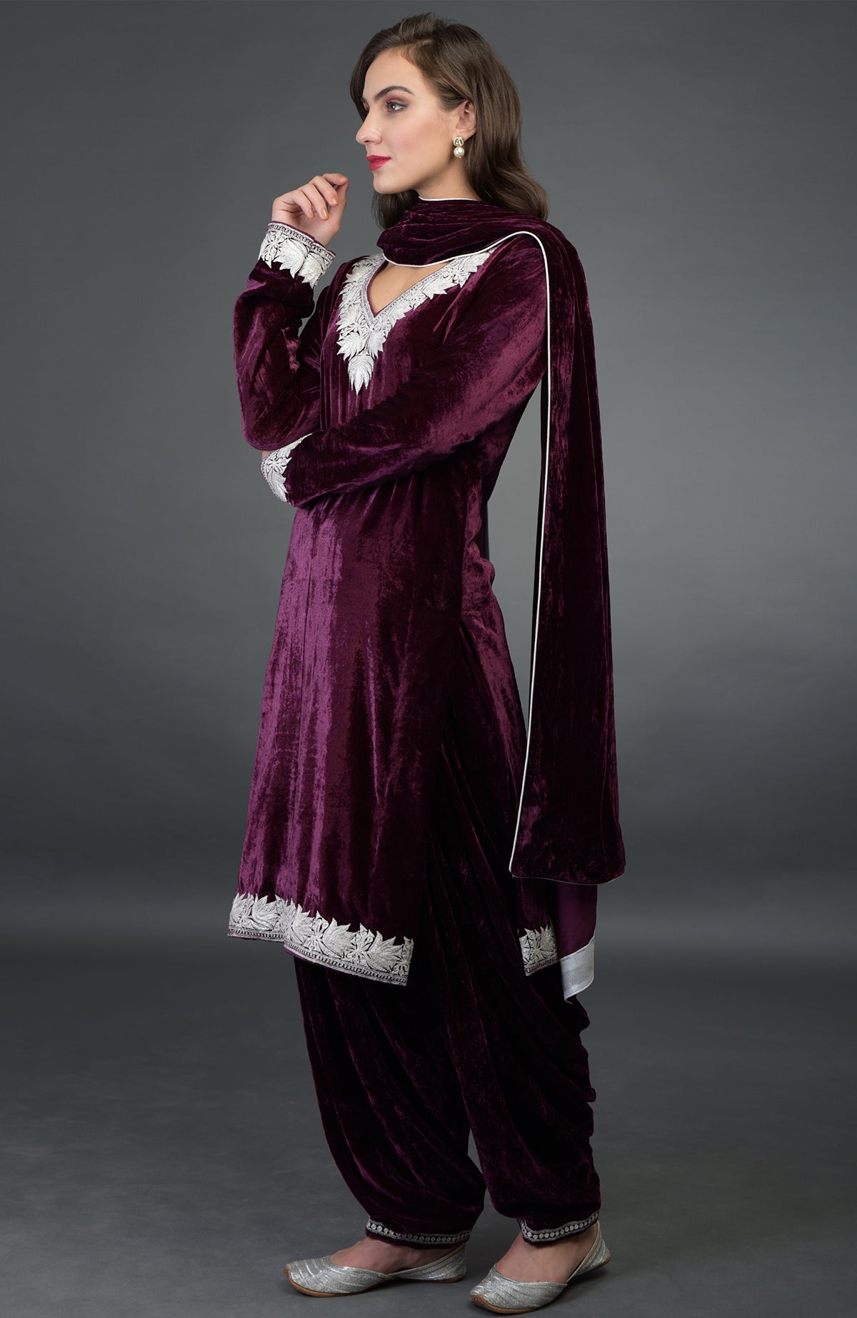A woman models a dark plum silk-velvet Patiala salwar suit with silver Tilla embroidery.
