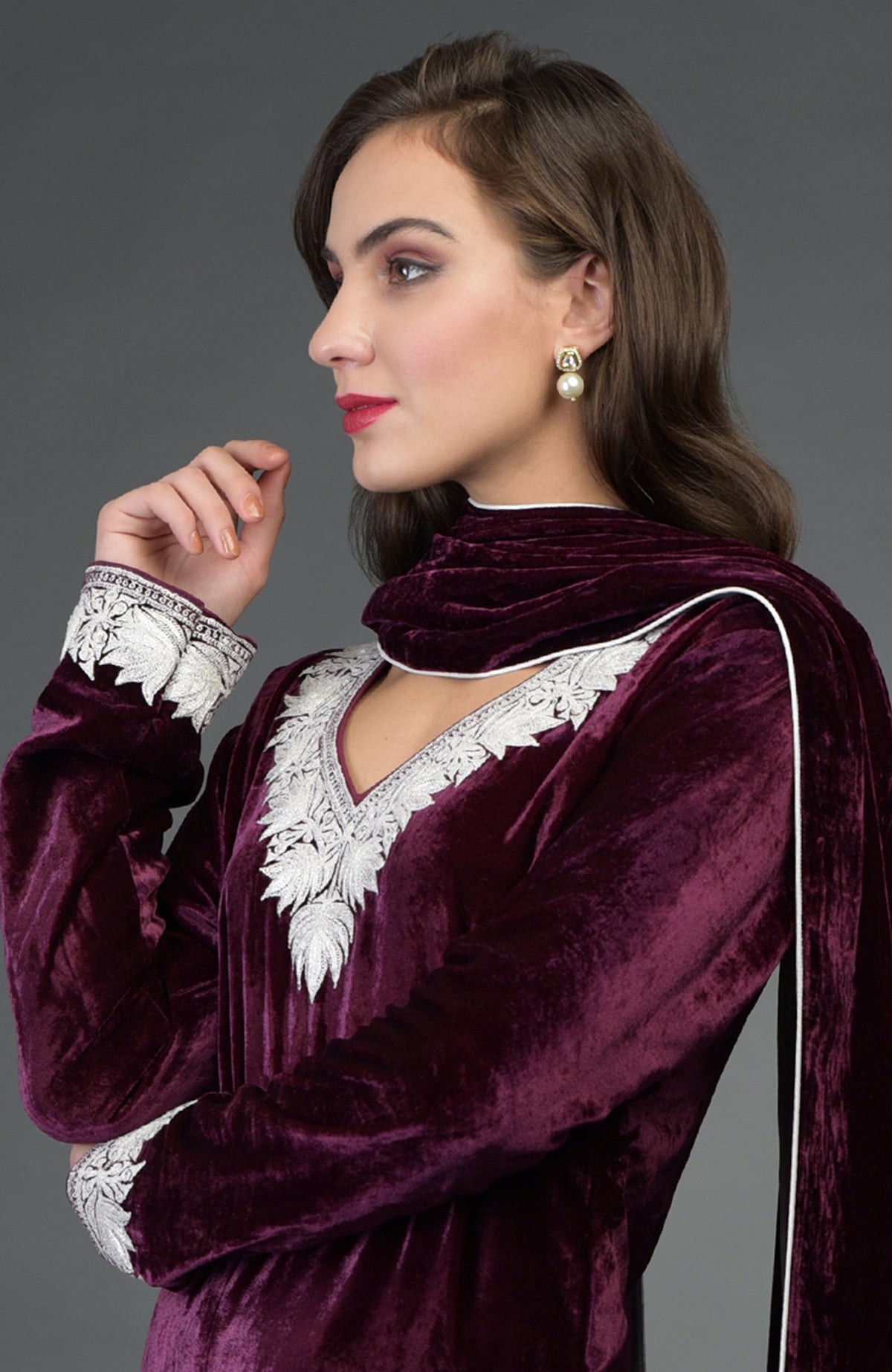 A woman models a dark plum velvet suit with silver embroidery and a matching dupatta.