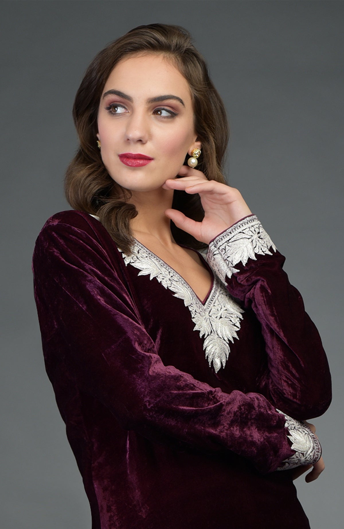 Woman wearing a dark plum silk-velvet tilla embroidered Patiala salwar suit.