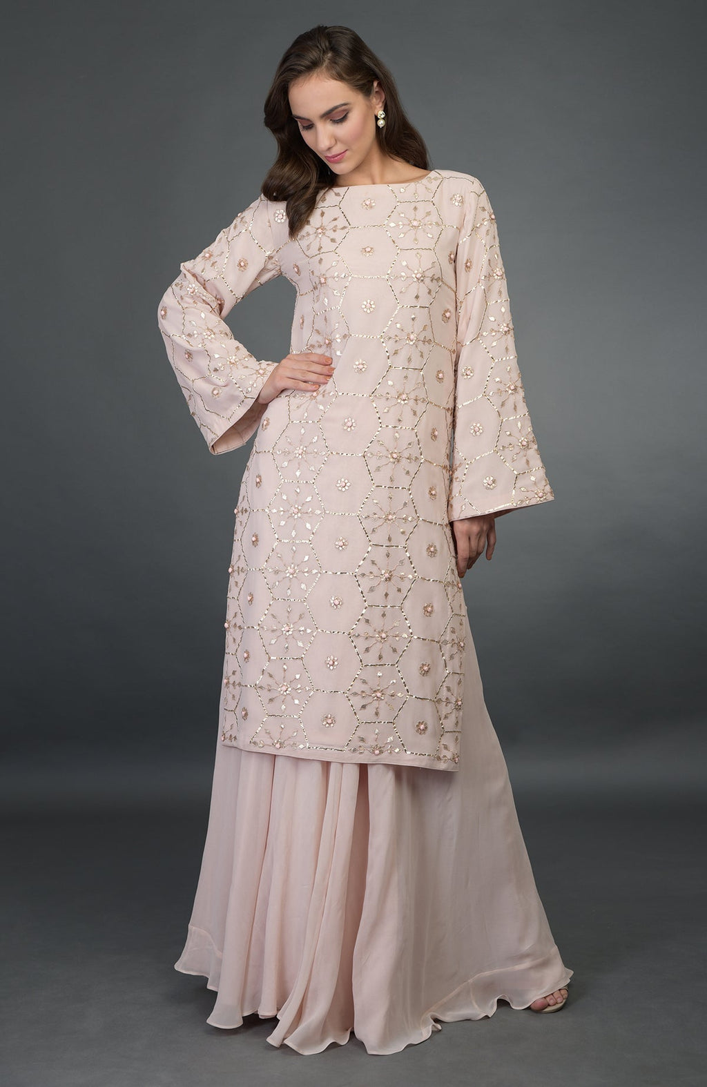 A woman models a nude pink suit with rose gold gota patti work.