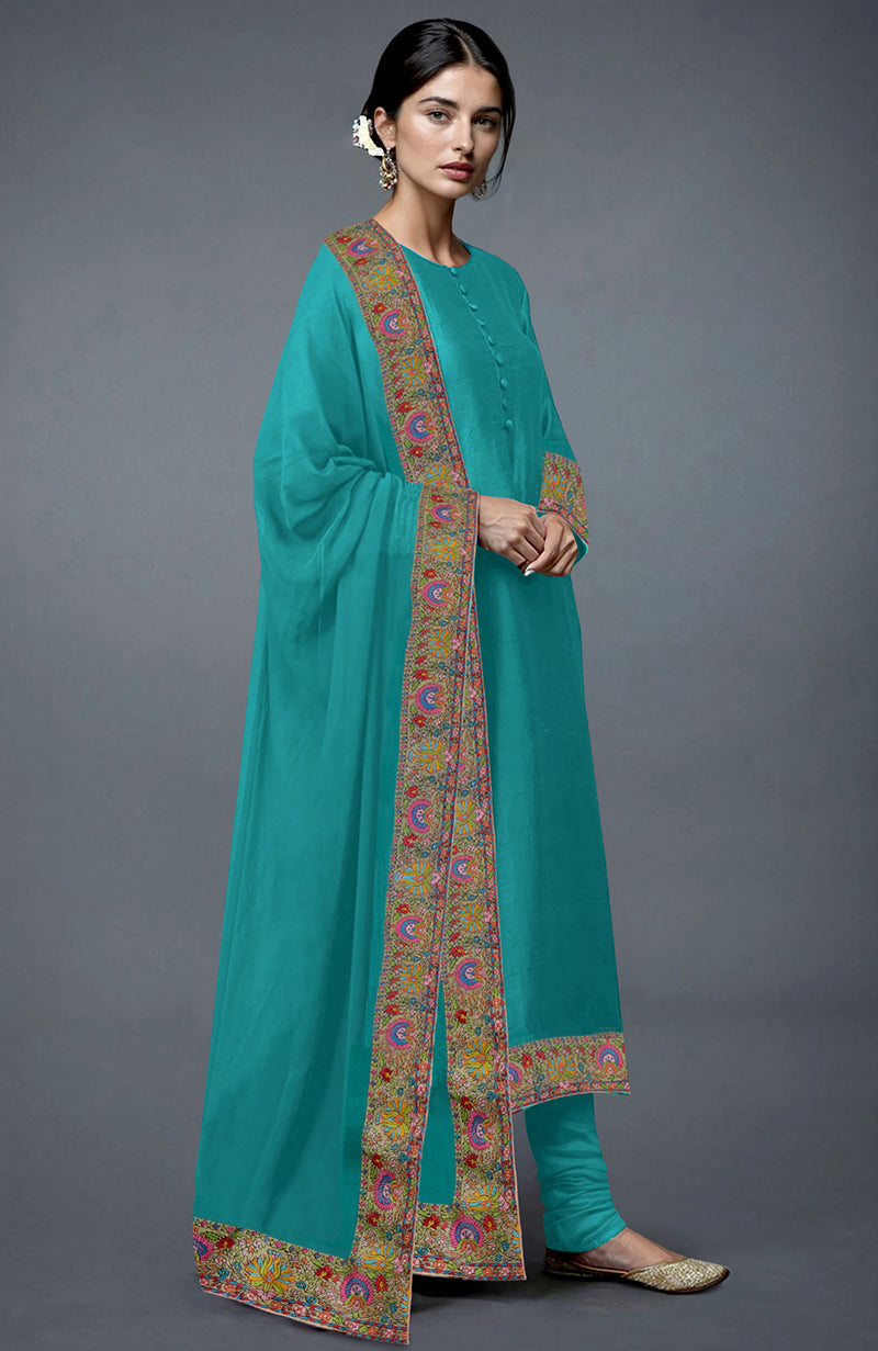A woman models a viridian green Kashmiri Kashidakari hand-embroidered suit.