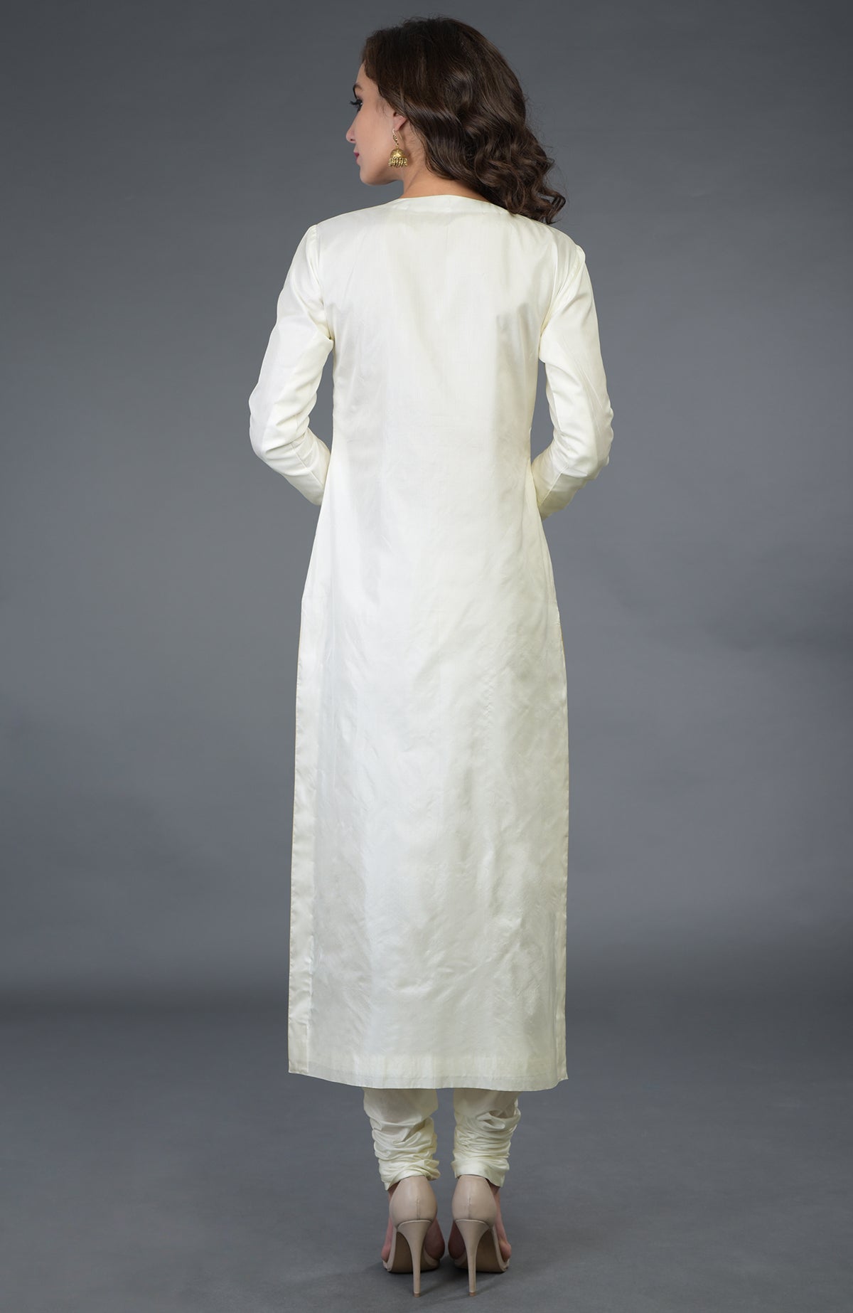 A woman from behind wears an ivory-gold pure silk suit with churidar and heels.