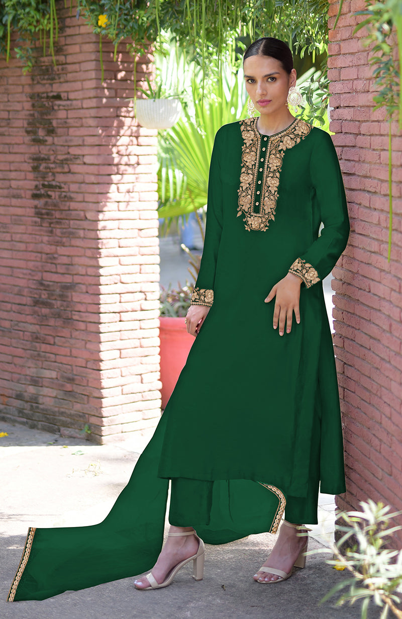 A woman models a dark green kurta set with gold embroidery on the neckline and cuffs.