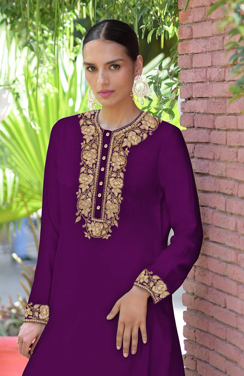A woman models a plum purple Kashmiri Tilla embroidered kurta set with gold embroidery.