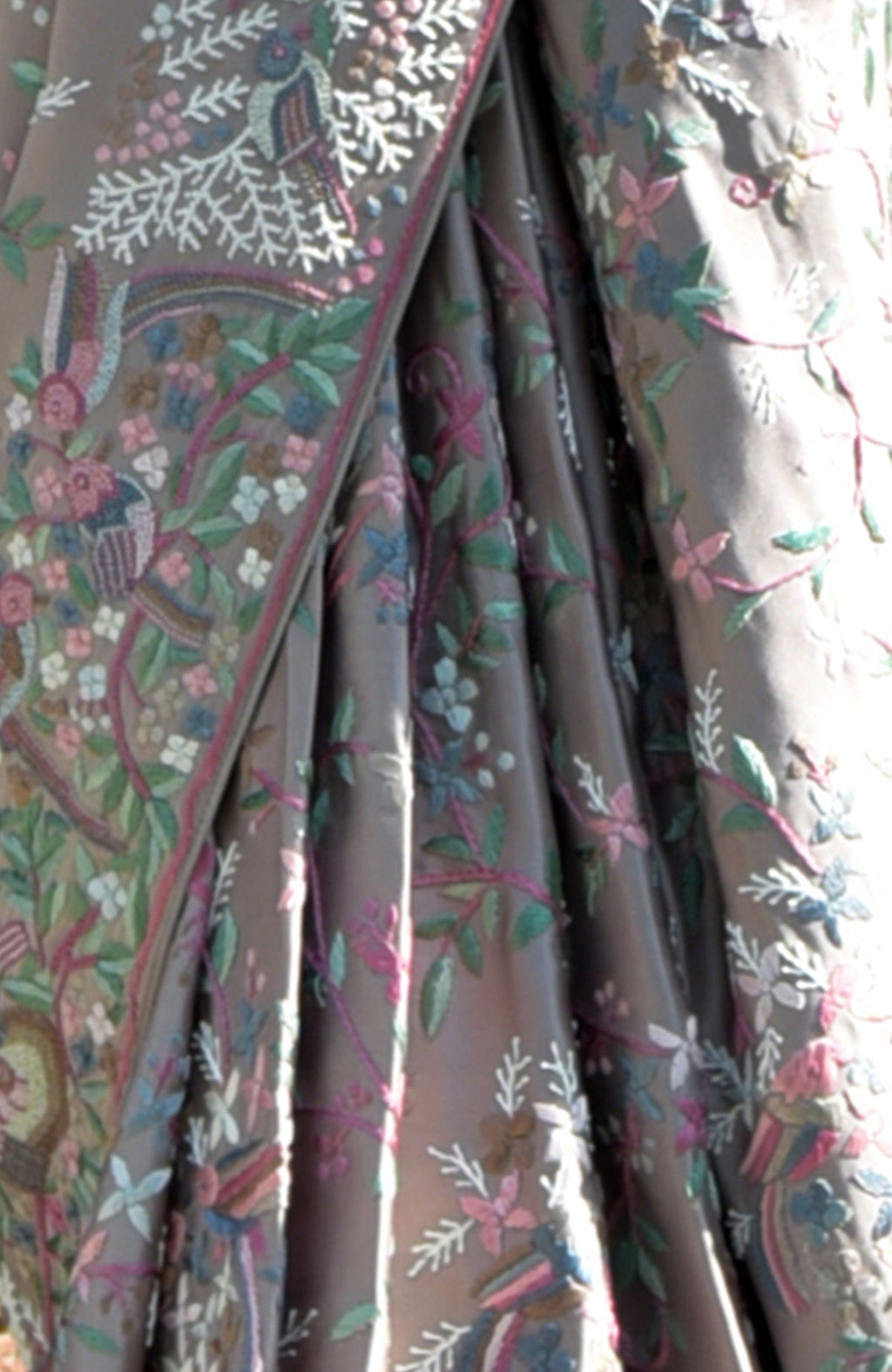 A close-up of a tea rose Parsi Gara hand-embroidered saree with floral and bird patterns.