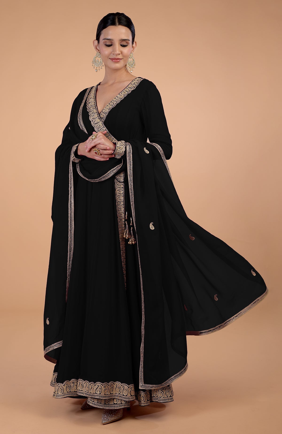 A woman in a black Angrakha Anarkali set with gold Kashmiri Tilla embroidery.