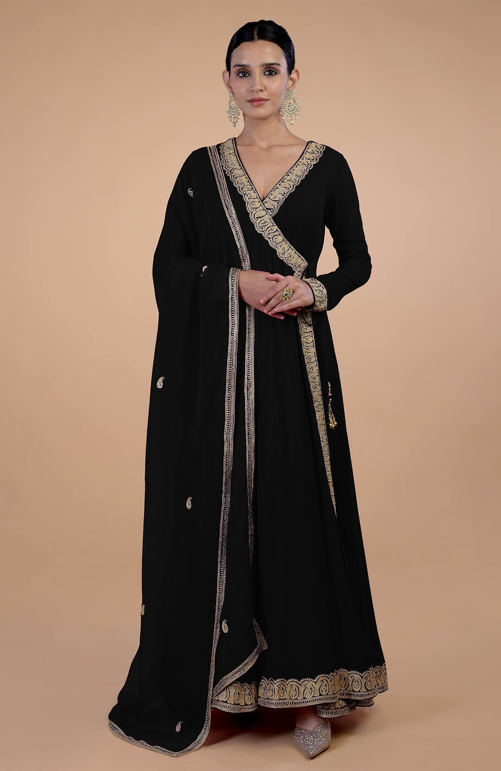 A woman models a black angrakha anarkali set with gold Kashmiri Tilla paisley embroidery.