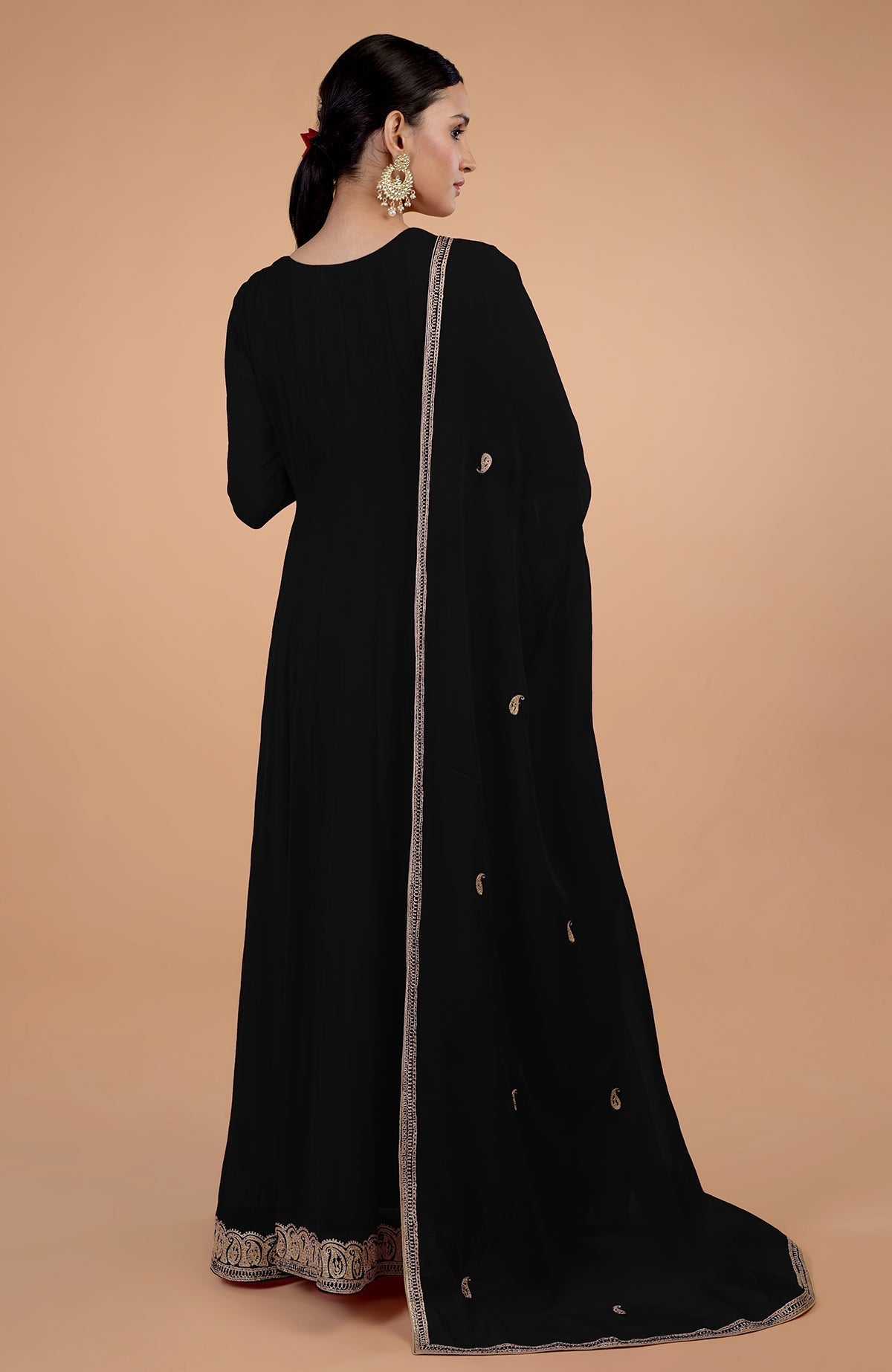 A woman in a black Angrakha Anarkali set with gold Kashmiri Tilla paisley embroidery.