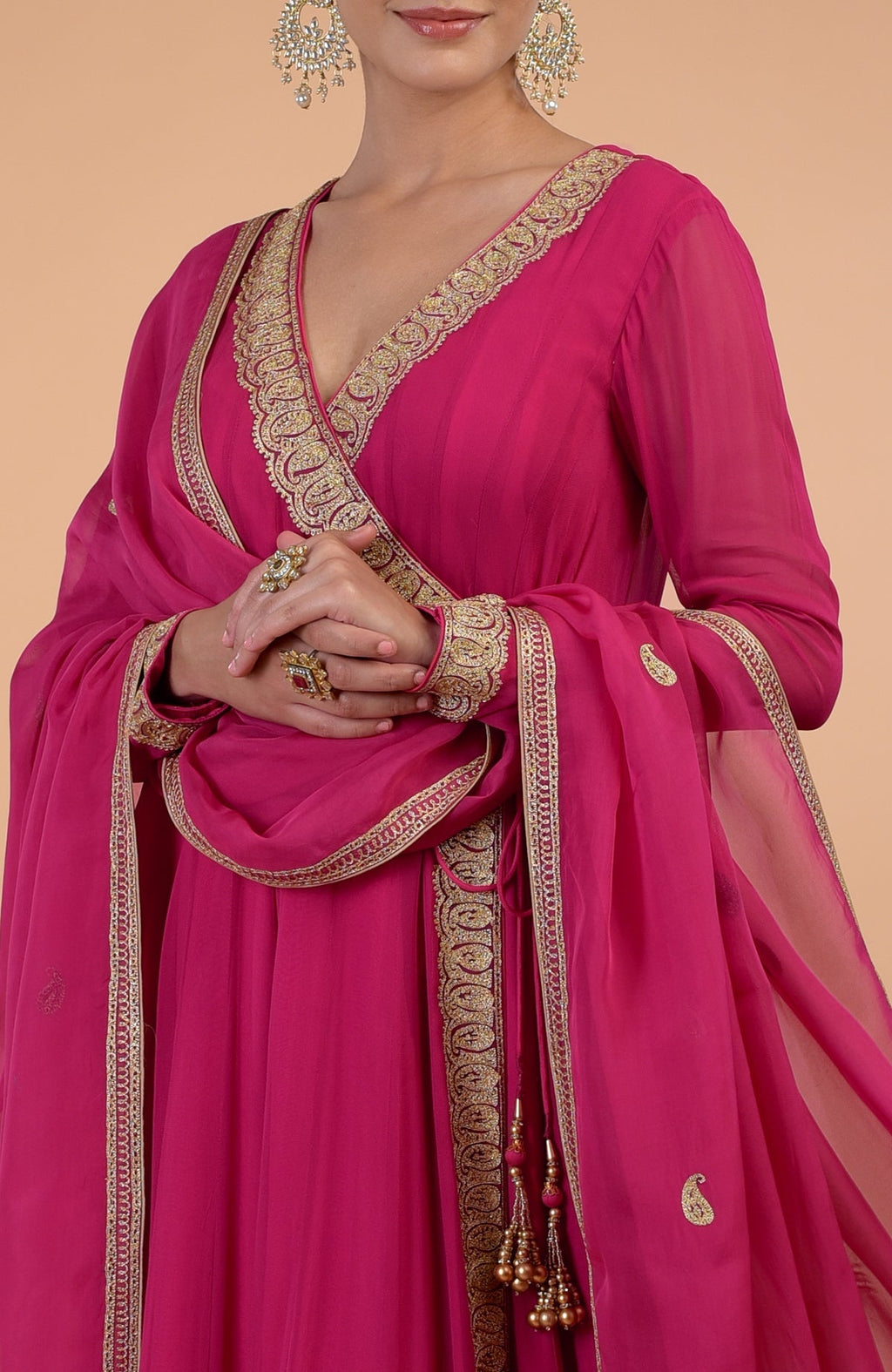 A raspberry pink angrakha anarkali set with gold Kashmiri Tilla paisley embroidery.