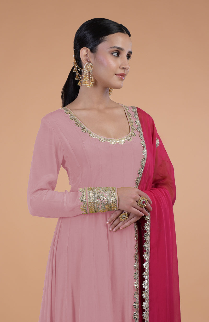 A woman models a pink Gota Patti embroidered Anarkali set with a deep pink dupatta.