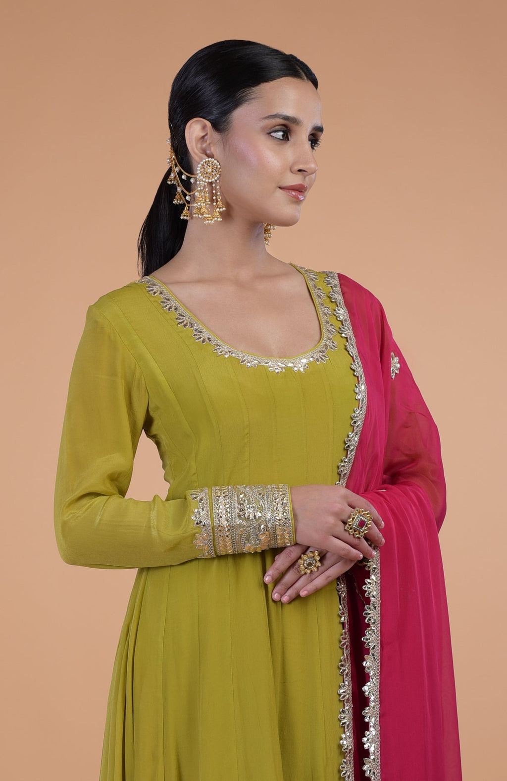 A woman models a citrus green anarkali set with a queen pink dupatta.