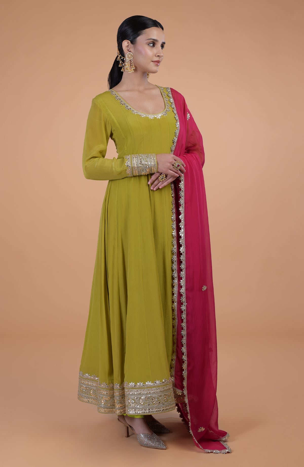A woman models a citrus green Anarkali set with a queen pink dupatta.