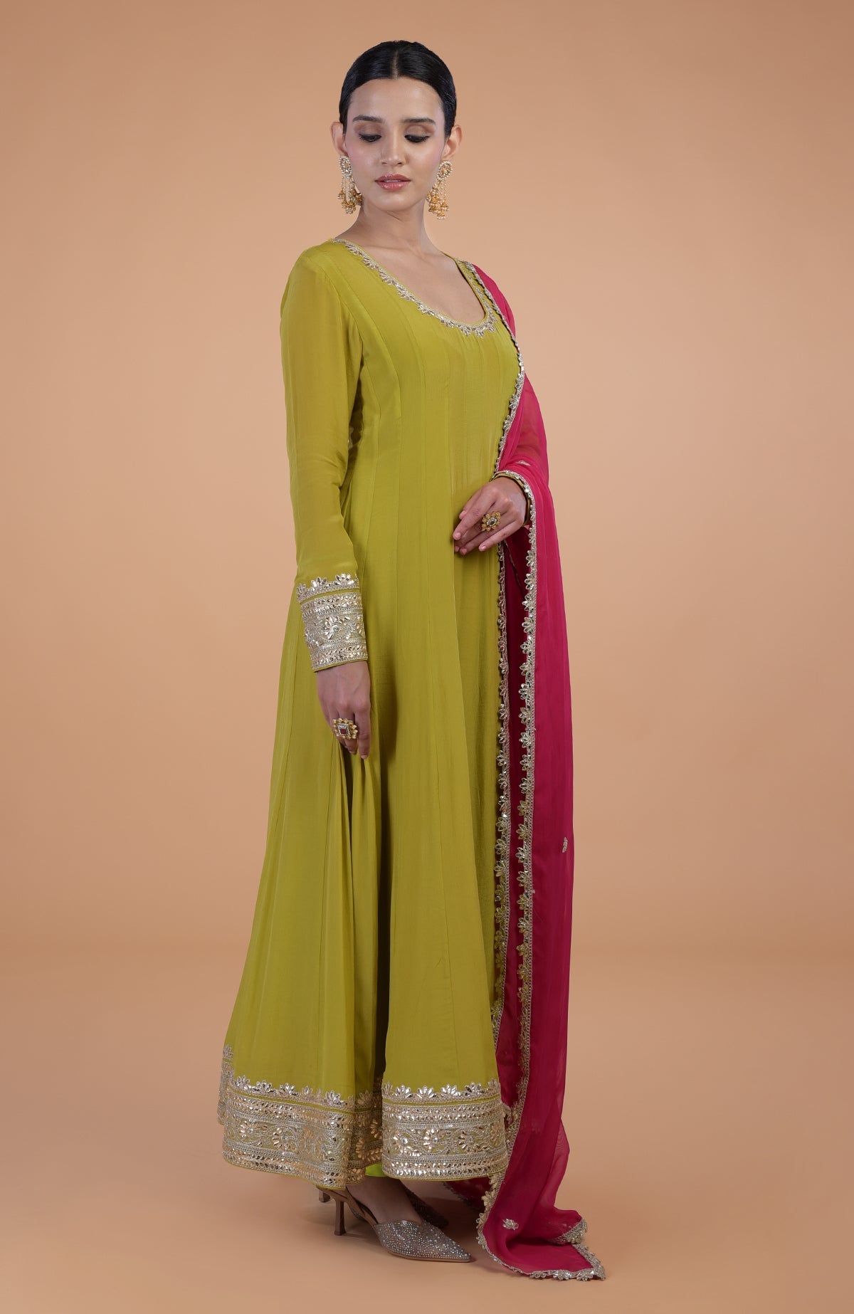 A woman models a citrus green Anarkali set with a queen pink dupatta.