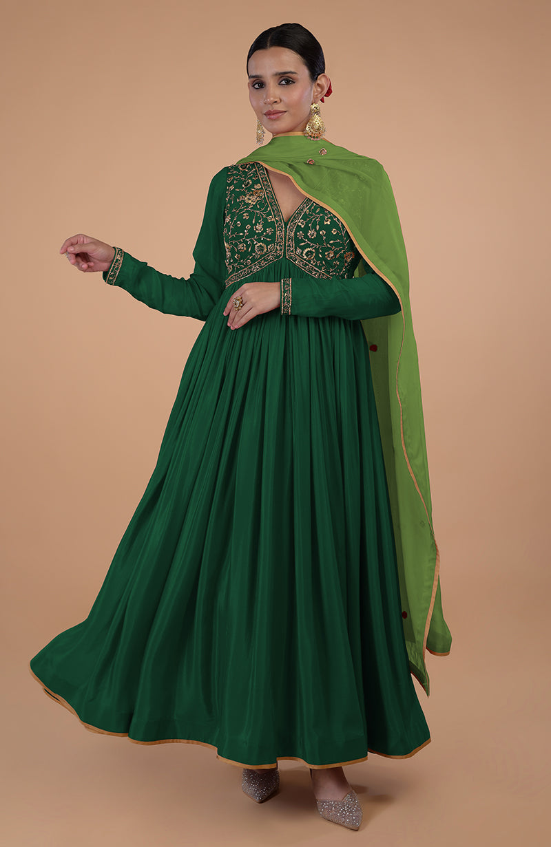 A woman models a bottle green anarkali set with zardozi and resham embroidery.