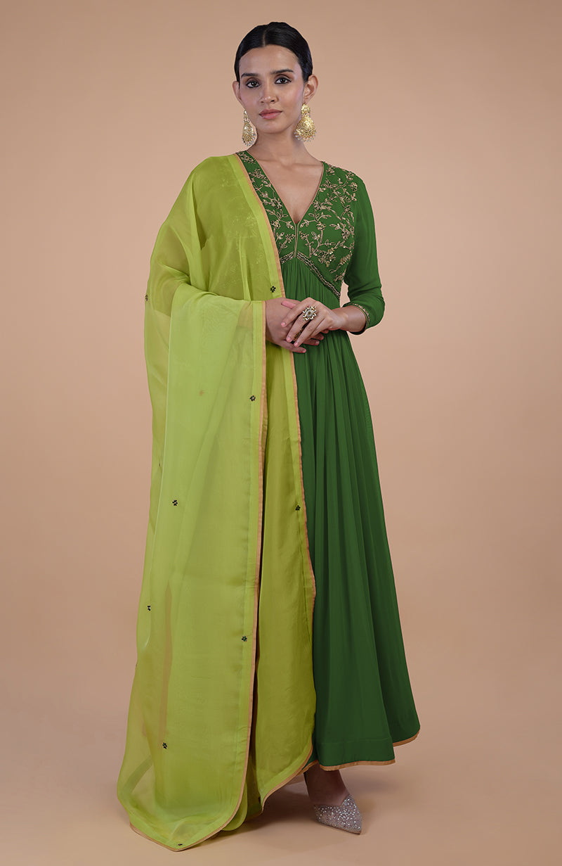 A woman models a green zardozi embroidered anarkali set with a lime green dupatta.