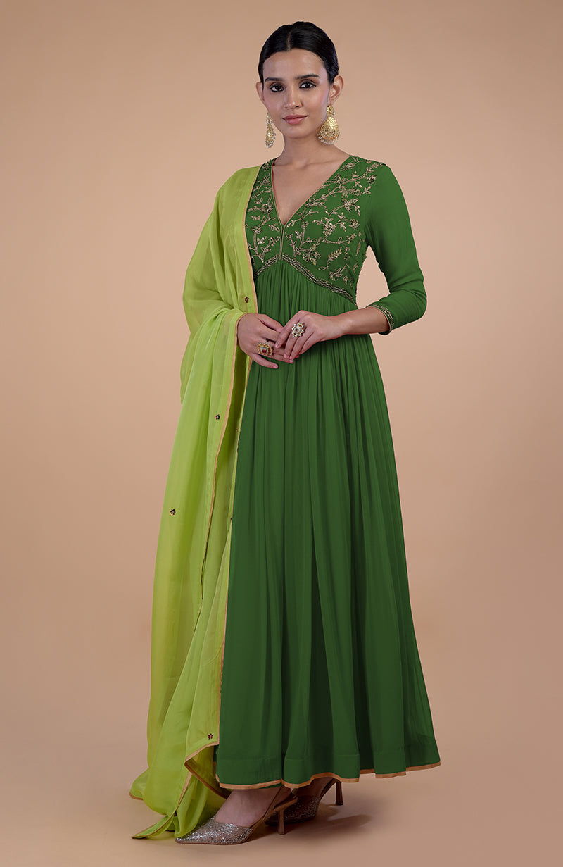 A woman models a green zardozi embroidered anarkali set with a matching dupatta.