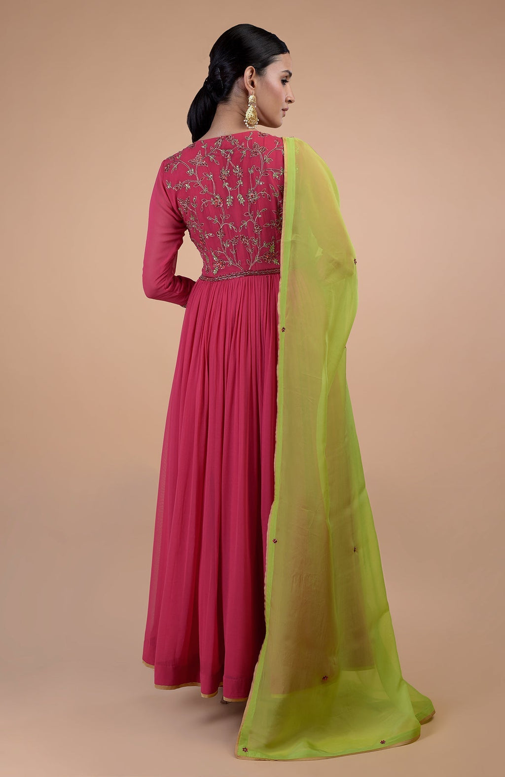 A woman models a pink anarkali set with green zardozi embroidered dupatta.