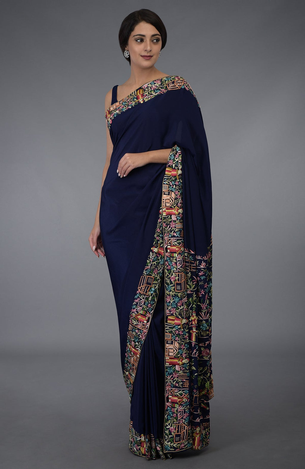 Midnight blue Parsi Gara hand-embroidered saree with colorful floral and figural motifs.