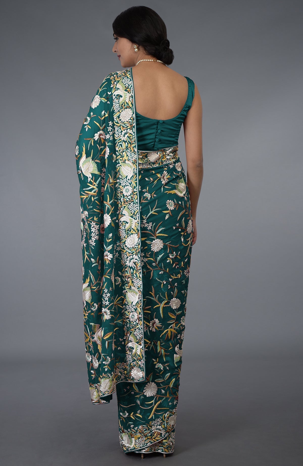 Teal Parsi Gara hand-embroidered saree with floral and bird motifs.