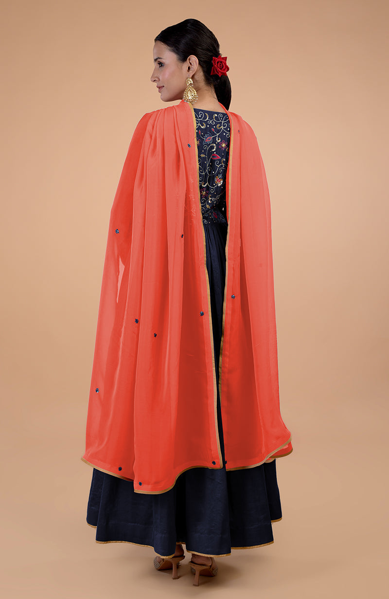 A woman models a navy blue and orange embroidered Anarkali set from the back.