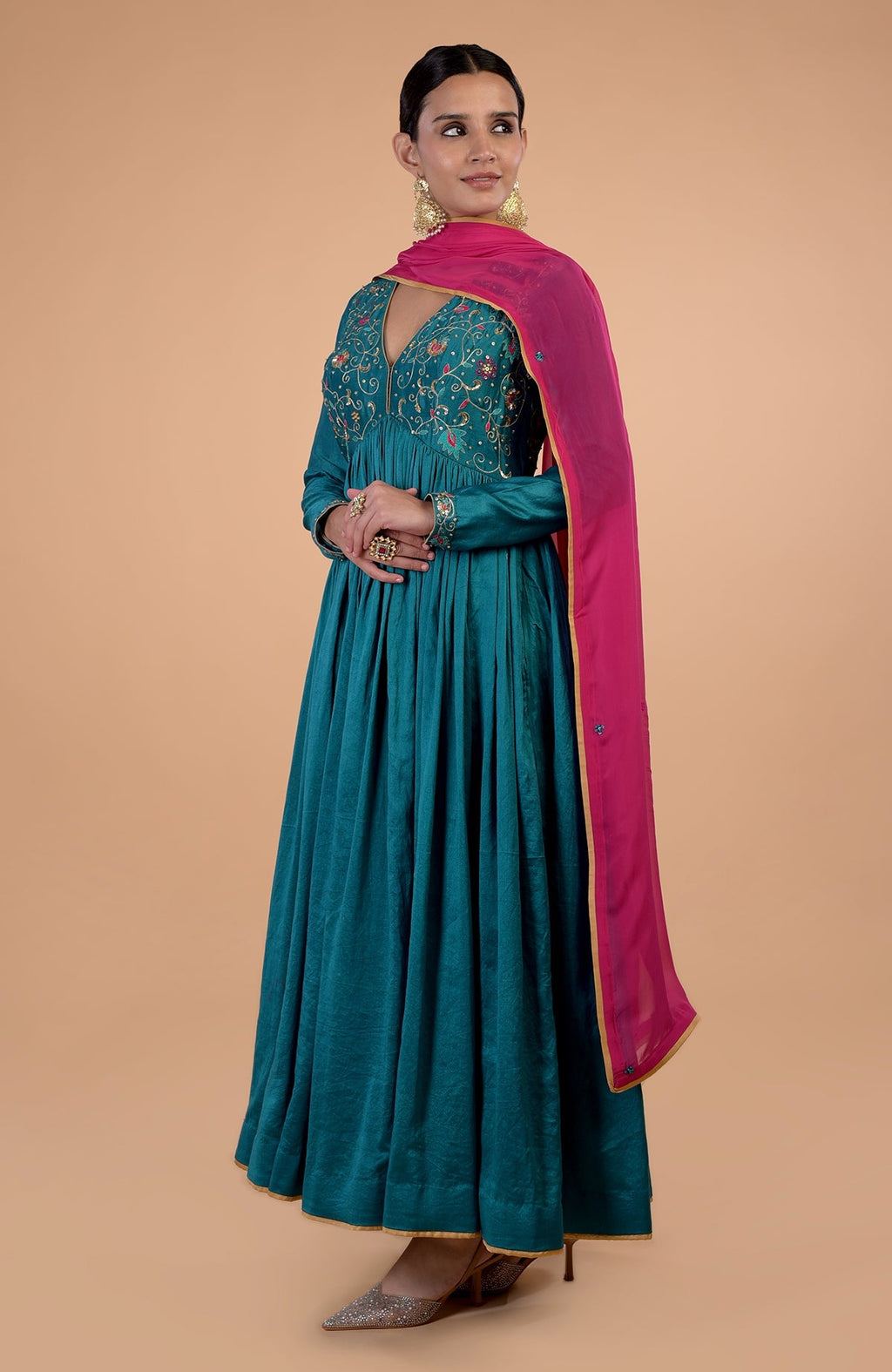 A woman models a teal anarkali set with pink zardozi embroidered dupatta.