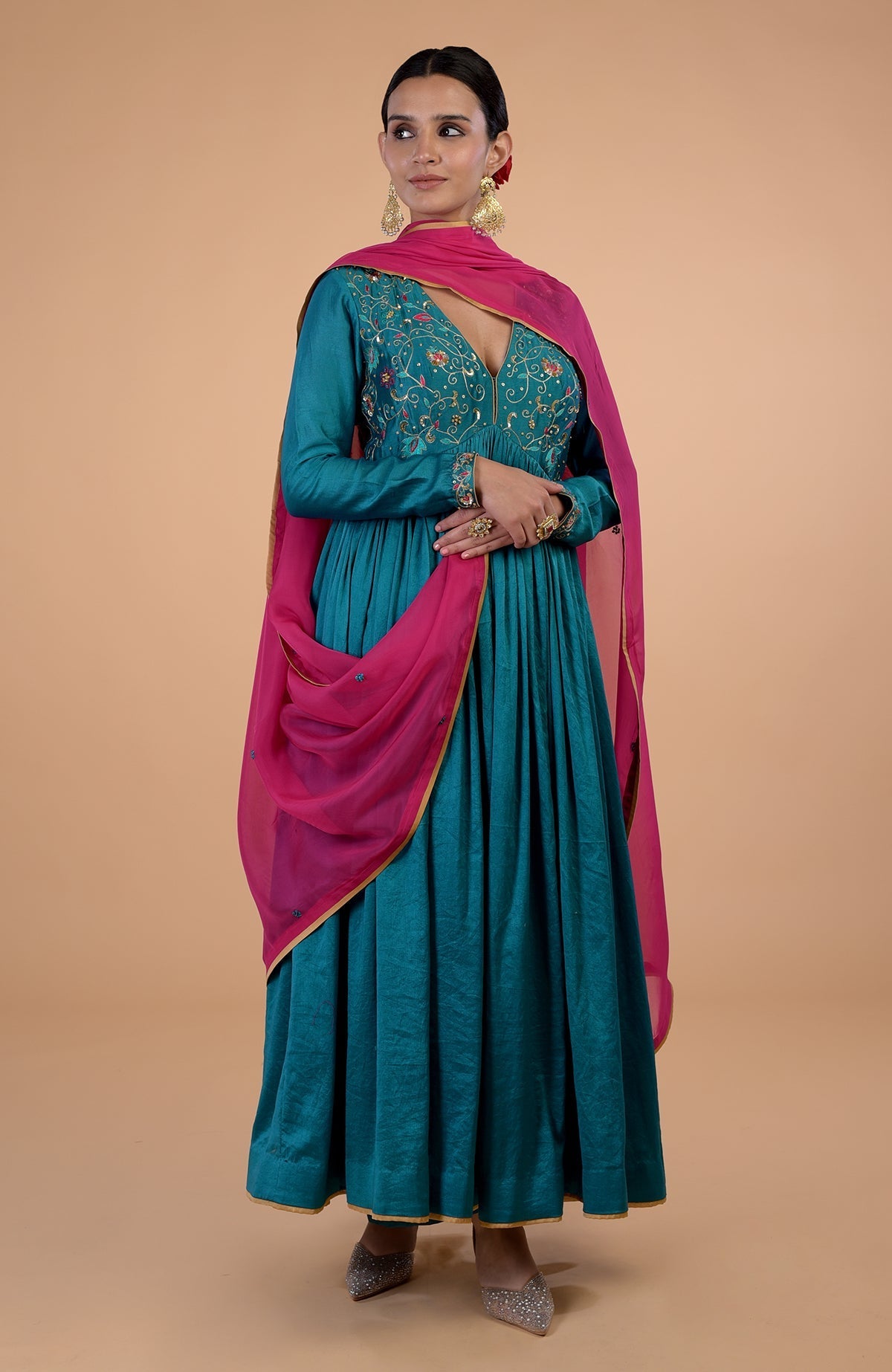 A woman models a teal anarkali set with pink zardozi embroidered dupatta.