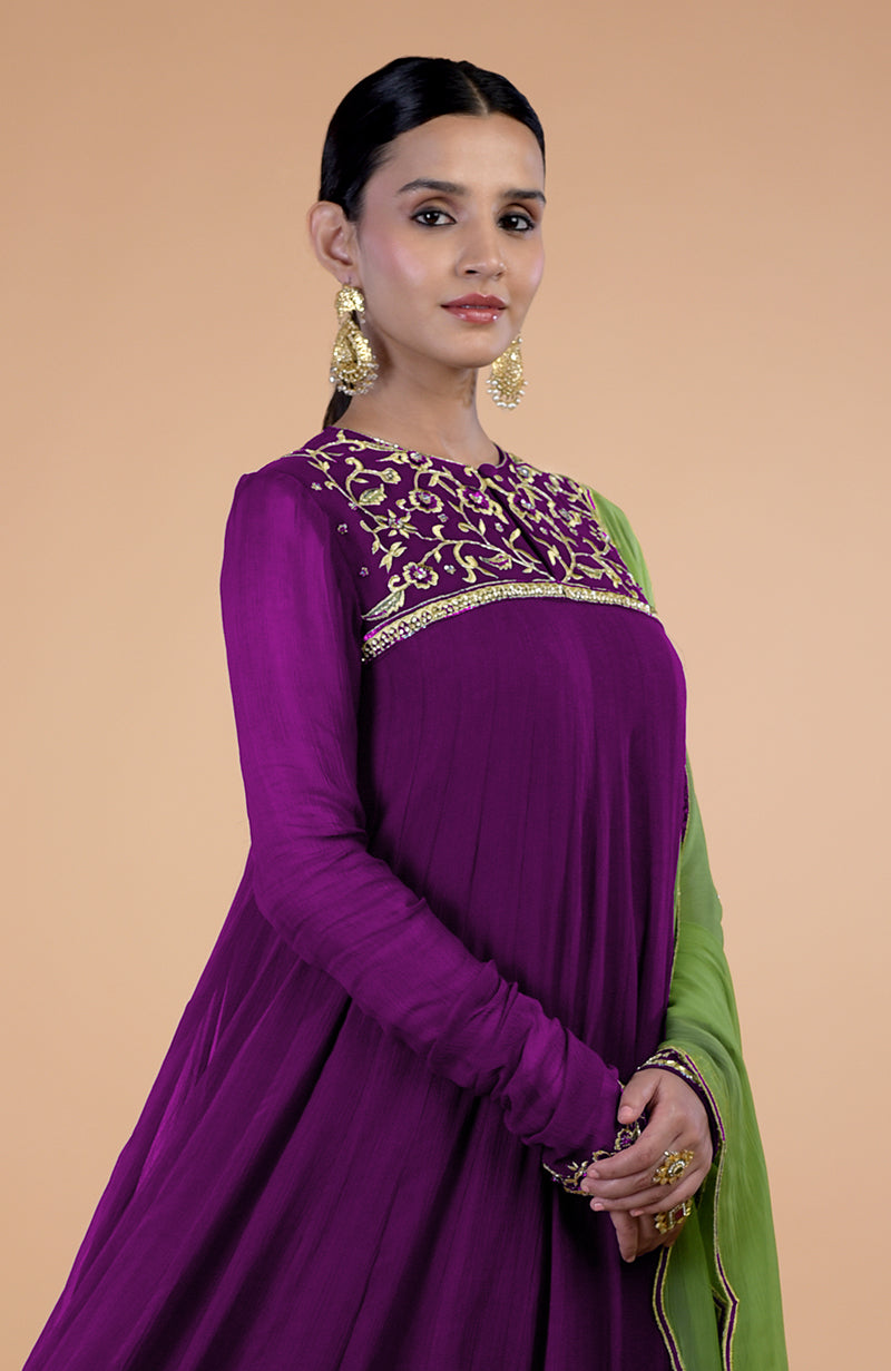 A woman models a plum-green resham and zardozi embroidered Anarkali set.