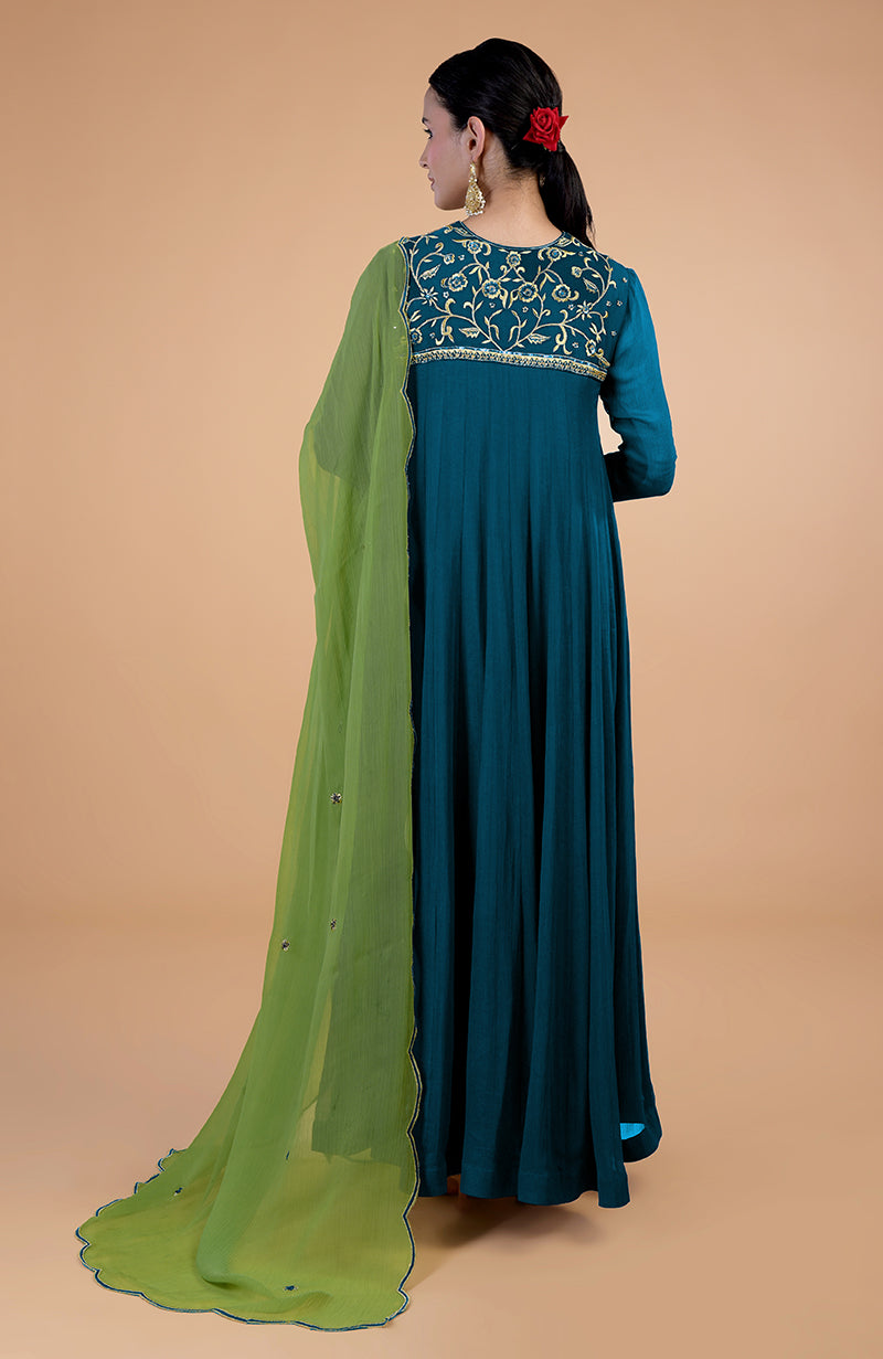 A woman from behind wears a teal-green anarkali set with a green dupatta.