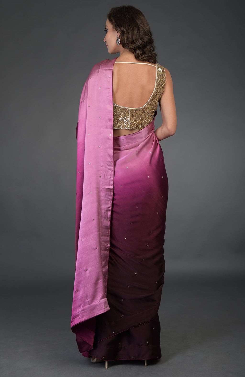 A woman models a wine-pink ombre sequin and zardozi hand-embroidered saree.